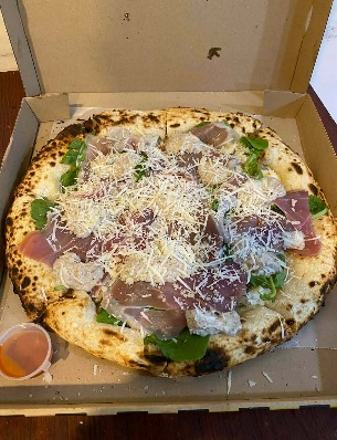 Amias pizza with Parma ham, mushrooms, arugula and cheese